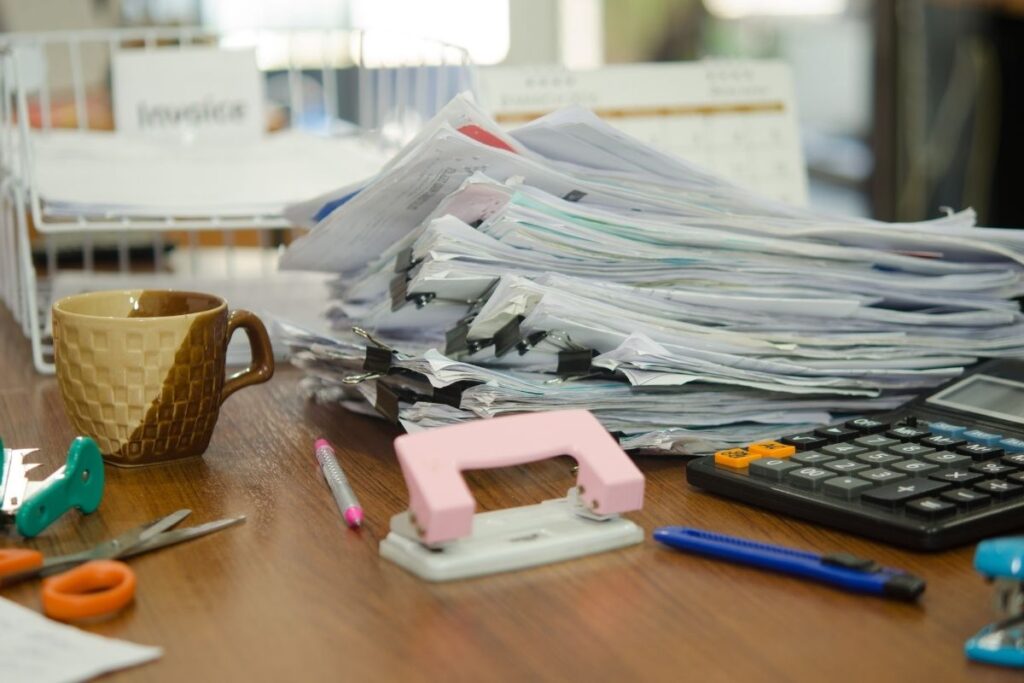 cluttered mail laying on desk